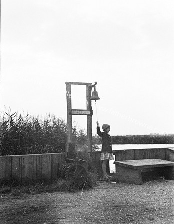 GIRL TOLLS BELL FOR FERRY